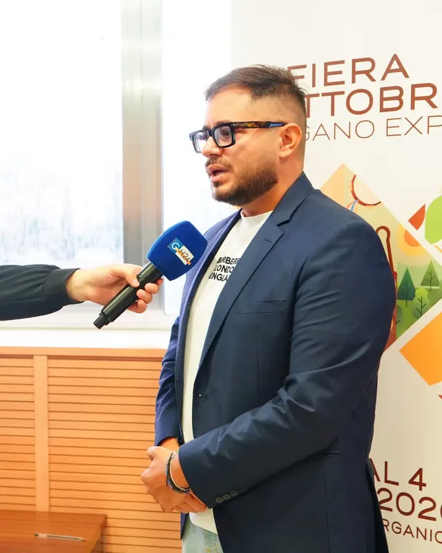 Intervista accanto al roll-up della fiera