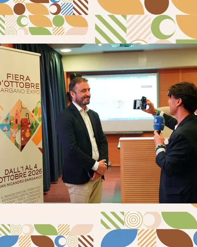 Intervista davanti al roll-up della fiera